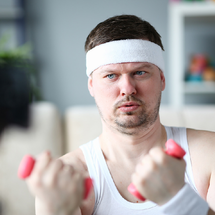 Harry Smith wearing aheadband and lifting comically small pink weights